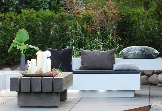 Hyggelig loungezone på oval terrasse med natursten