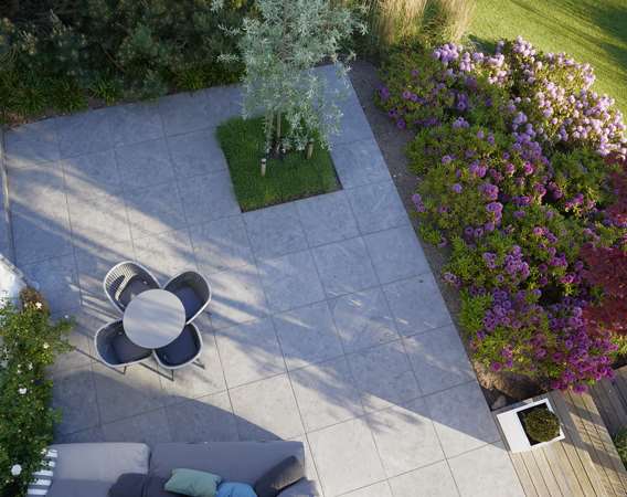 Terrasse med natursten og pilebladet pære designet af havearkitekt Tor Haddeland